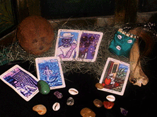 A black table with tarot cards, stones, and a gris gris bag resting on it.