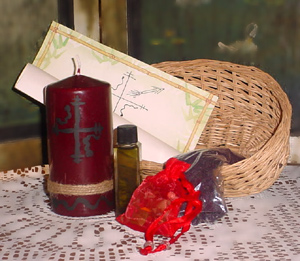 A deep red candle, incense powder, a gris gris bag, and an incantation in a small basket